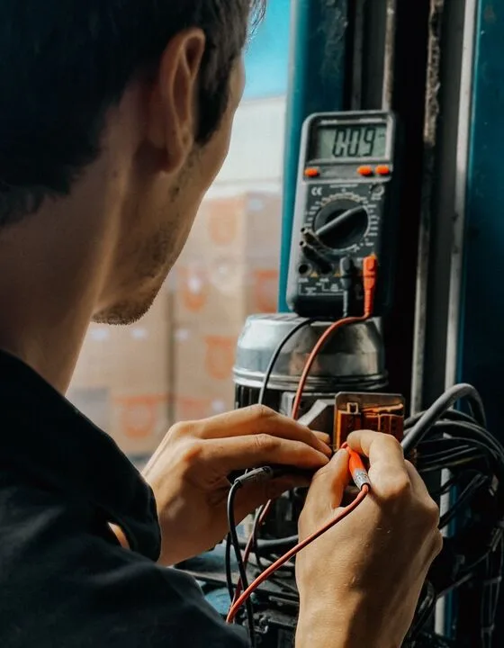 SydTag technician using a portable appliance tester to test and tag electrical equipment in a Sydney workplace